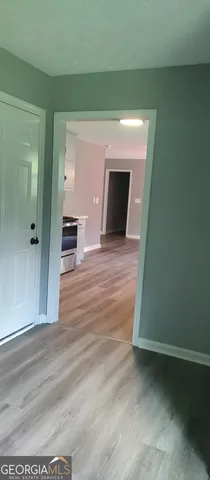 a view of a livingroom with wooden floor and a fireplace