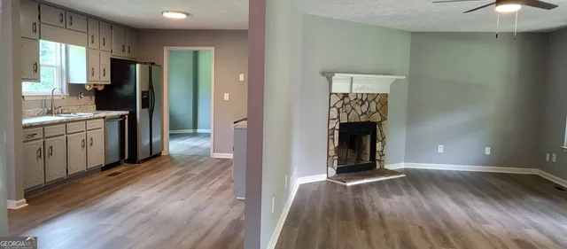 a view of a kitchen with wooden floor and a refrigerator