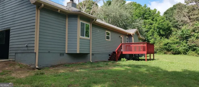 a backyard of a house with wooden fence and a toy car