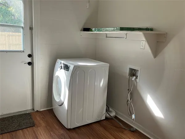 a utility room with wooden floor washer and dryer