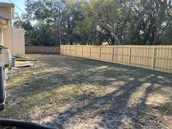 a view of a yard with trees in the background