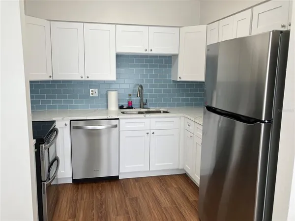 a kitchen with a sink a refrigerator and cabinets
