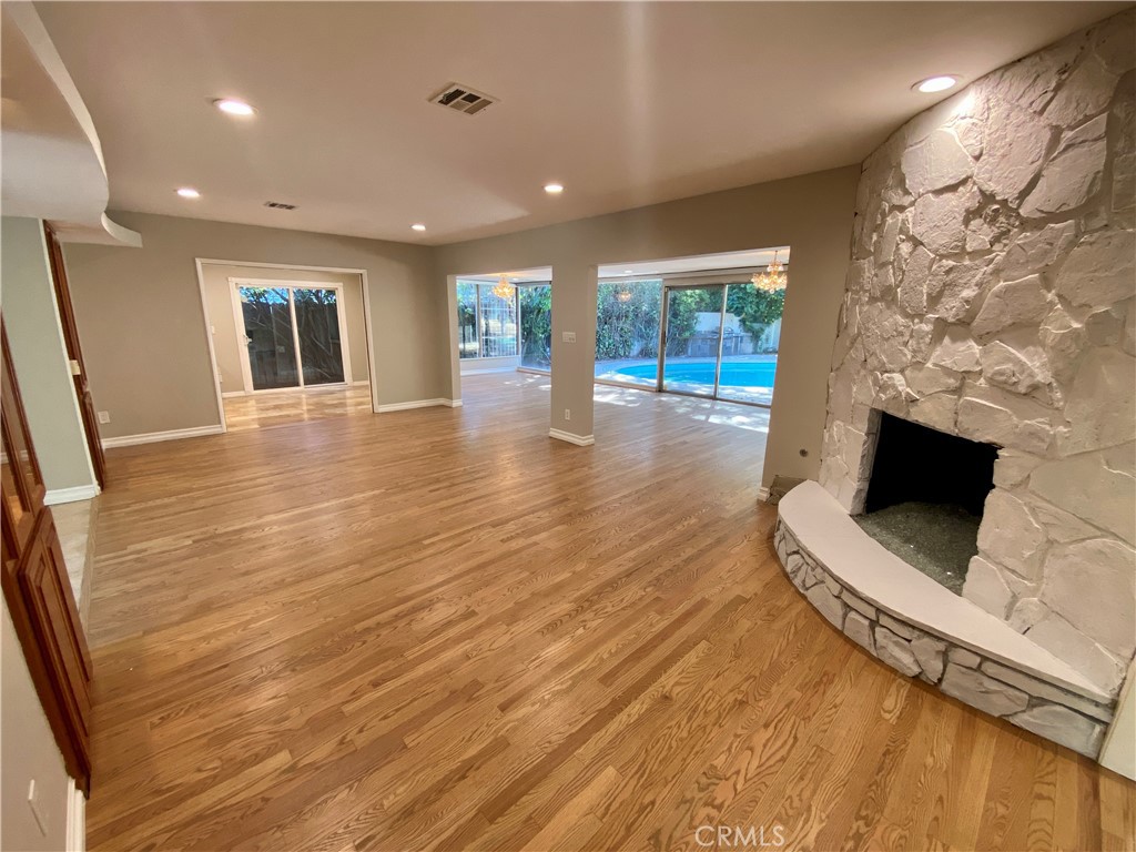 an empty room with wooden floor and fireplace