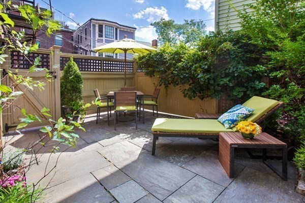 a view of a patio with a table and chairs and potted plants
