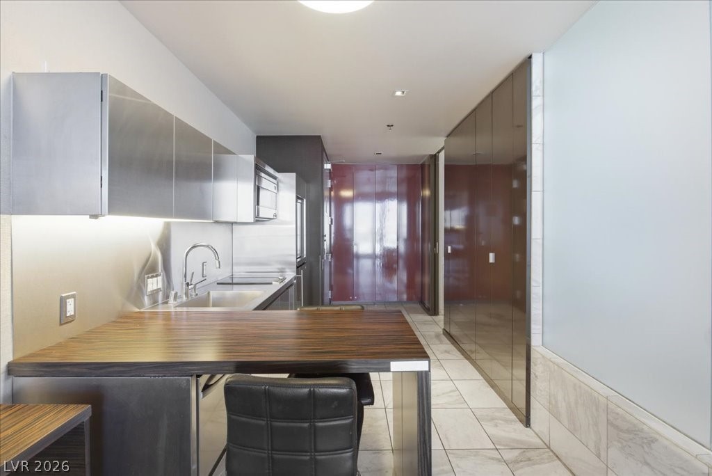 4381 West Flamingo Road, Unit 10306 Las Vegas, NV 89103 - Photo 5 of 26 This sleek kitchen features modern appliances and a functional dining area.