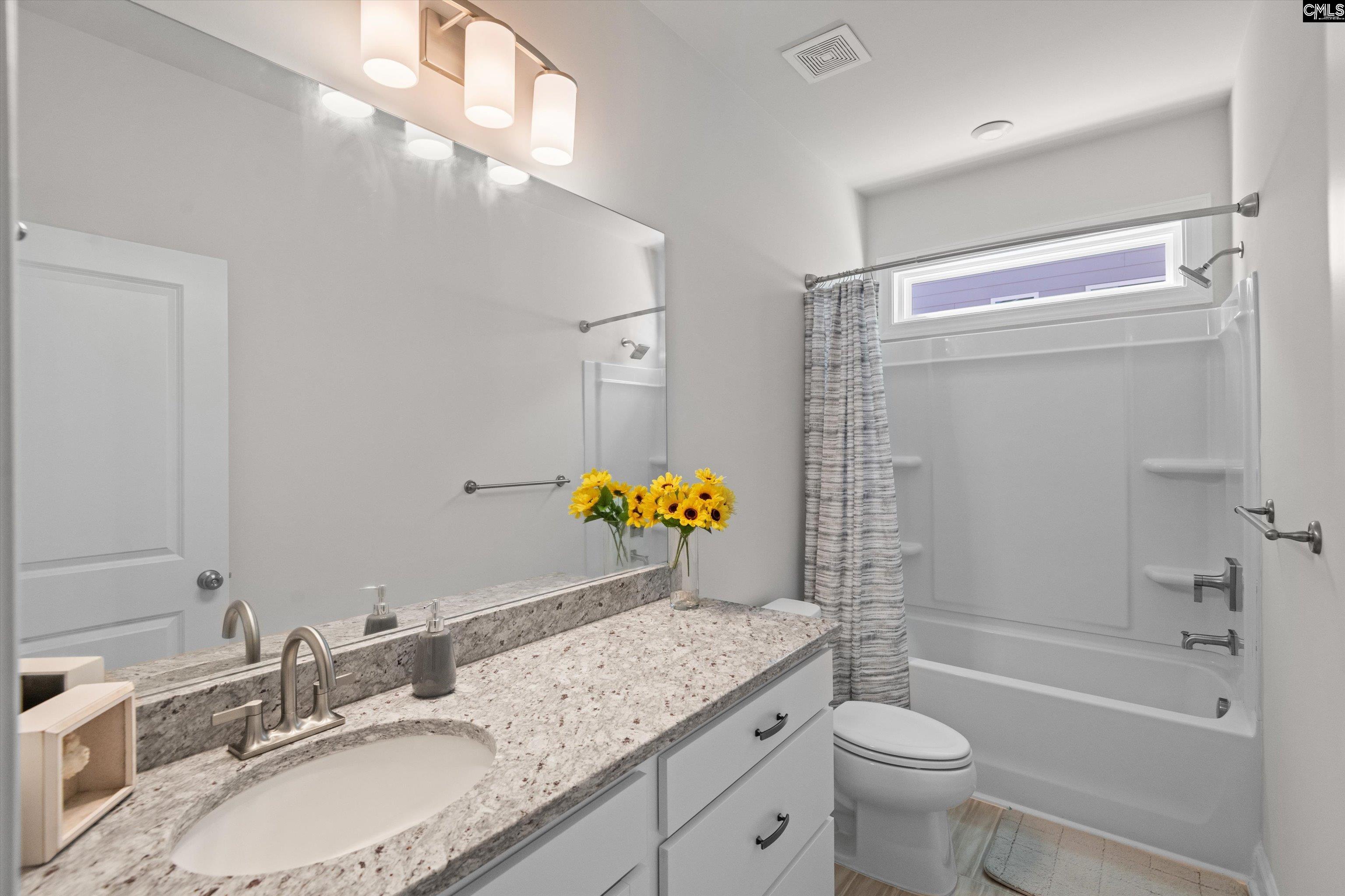 558 Wild Ginger Loop Irmo, SC 29063 - Photo 29 of 42 a bathroom with a granite countertop sink a toilet and shower