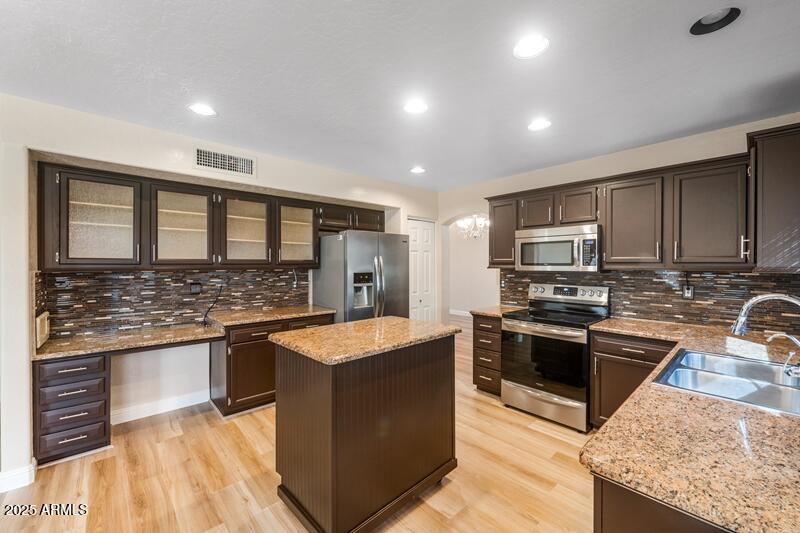 1691 West Commerce Avenue Gilbert, AZ 85233 - Photo 11 of 34 a large kitchen with stainless steel appliances granite countertop a stove and a sink
