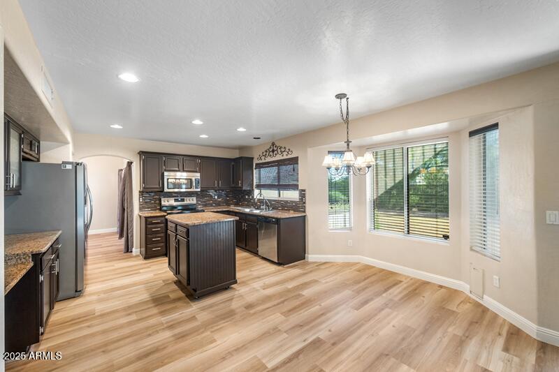 1691 West Commerce Avenue Gilbert, AZ 85233 - Photo 12 of 34 a large kitchen with kitchen island a large counter top space a sink stainless steel appliances and cabinets