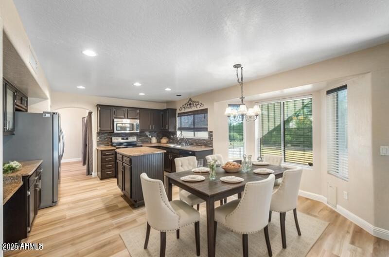 1691 West Commerce Avenue Gilbert, AZ 85233 - Photo 13 of 34 a kitchen with a dining table chairs and refrigerator