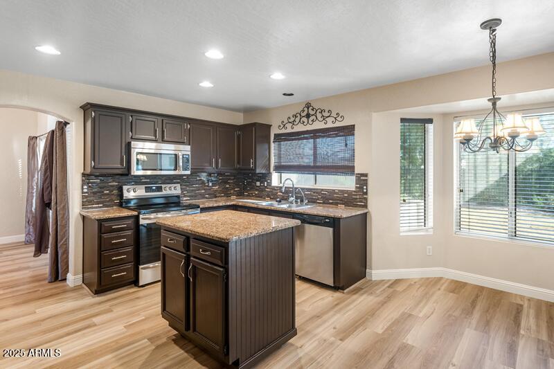 1691 West Commerce Avenue Gilbert, AZ 85233 - Photo 14 of 34 a kitchen with kitchen island granite countertop a sink appliances and cabinets