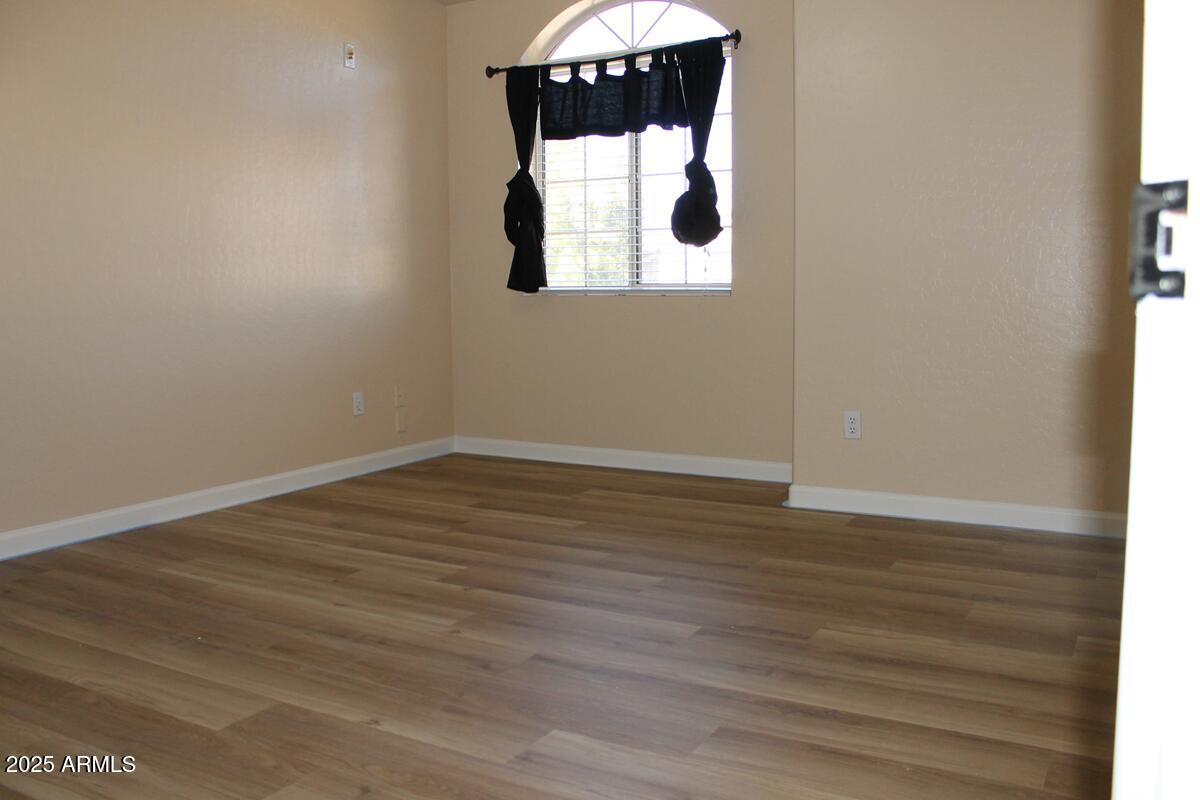 1691 West Commerce Avenue Gilbert, AZ 85233 - Photo 26 of 34 an empty room with wooden floor and windows