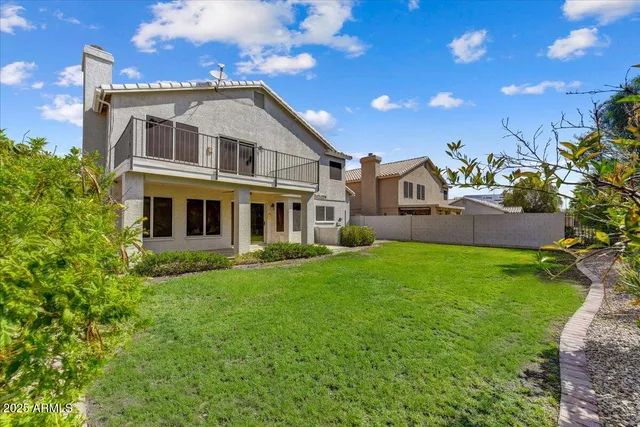 a yard with lots of green space and trees in the background