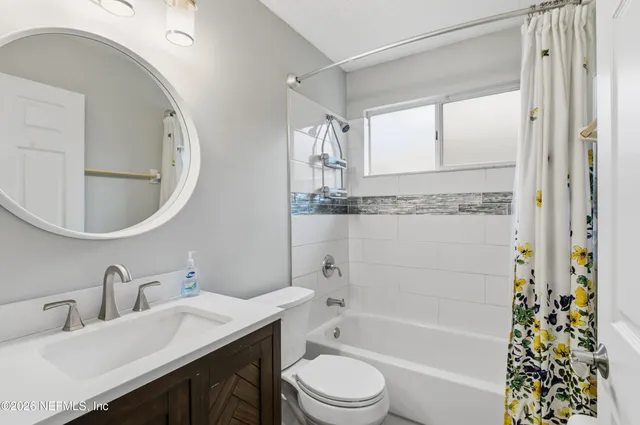 a bathroom with a bathtub sink vanity mirror and toilet