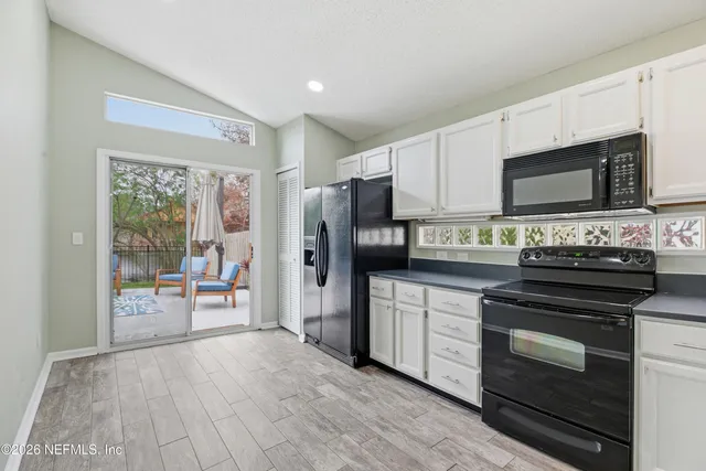 a kitchen with granite countertop a refrigerator stove and microwave