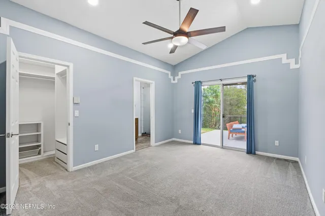 an empty room with windows and ceiling fan