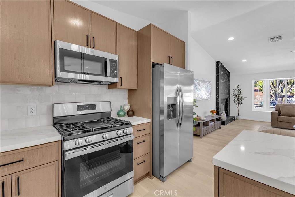 9740 Capiland Road Desert Hot Springs, CA 92240 - Photo 5 of 59 a kitchen with stainless steel appliances a refrigerator stove and microwave