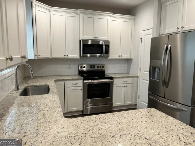 a kitchen with stainless steel appliances a refrigerator sink and microwave