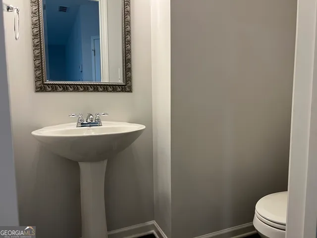 a bathroom with a sink toilet and mirror