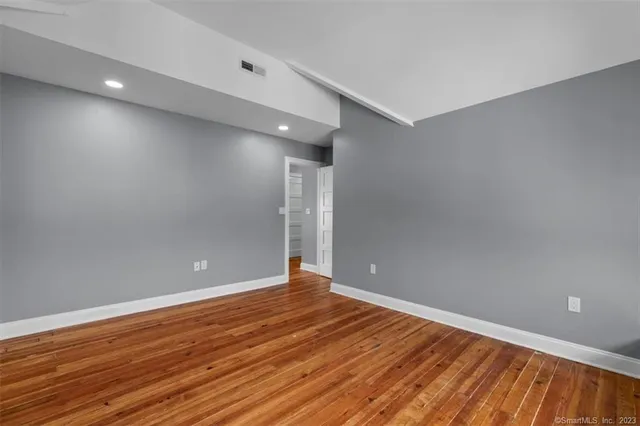 a view of an empty room with wooden floor