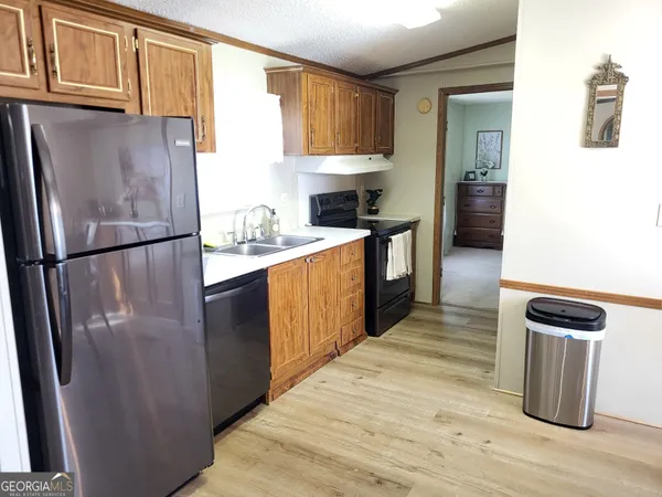 a kitchen with stainless steel appliances a stove refrigerator and a microwave