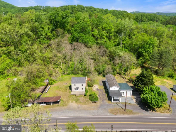 an aerial view of residential houses with outdoor space and trees