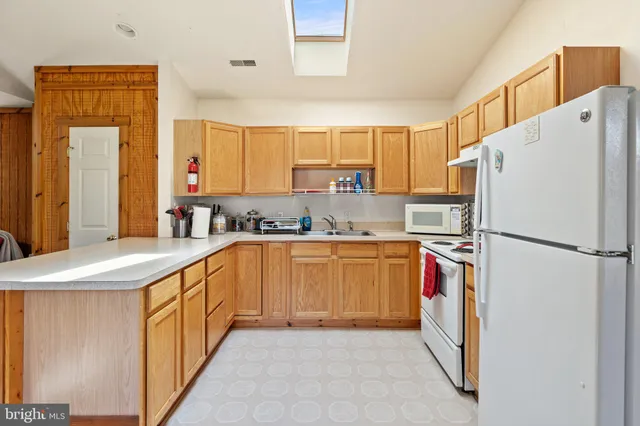 a living room with furniture a flat screen tv and kitchen view