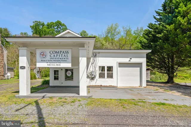 a view of house with outdoor space and a parking space