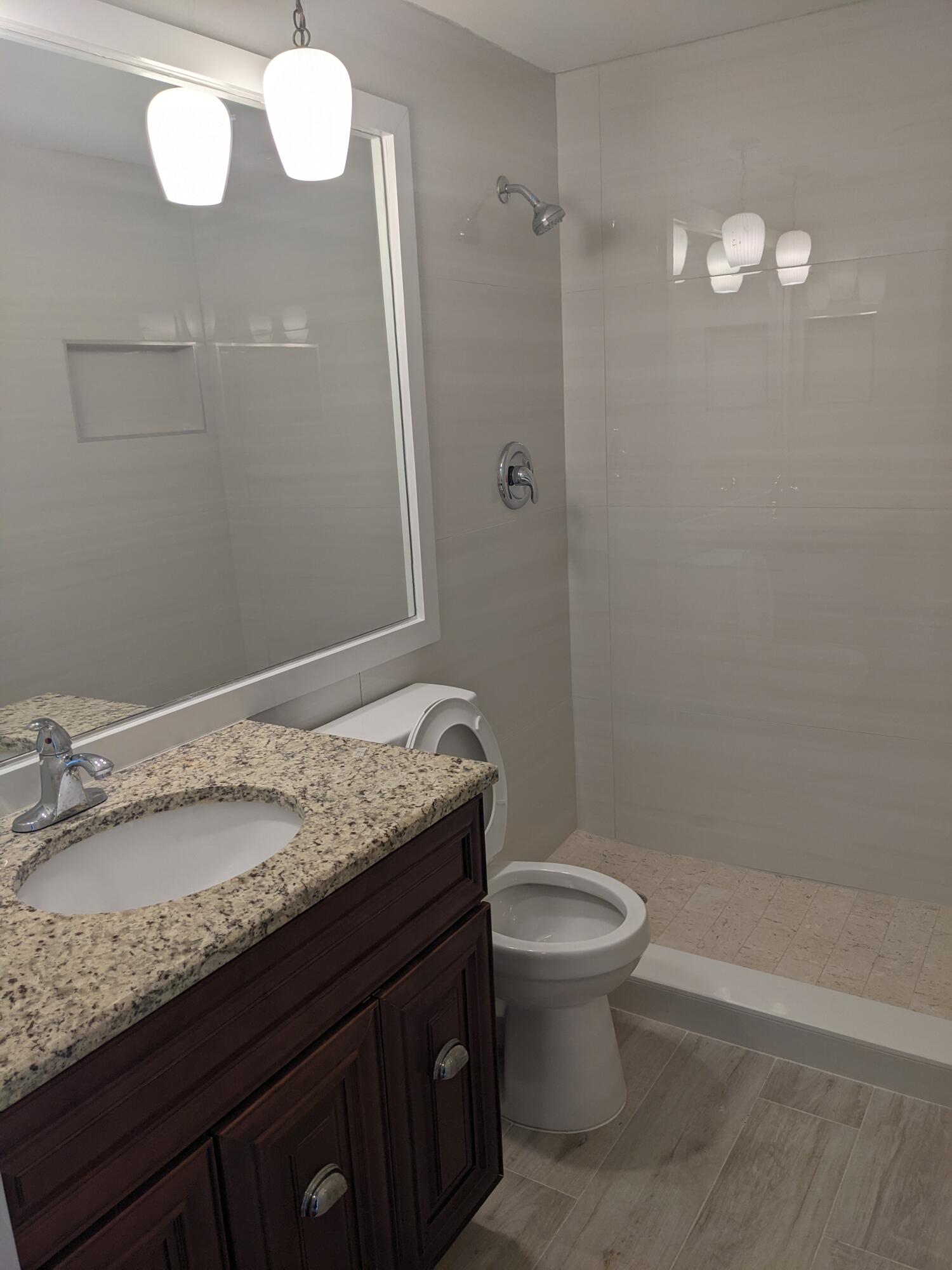 2772 Northeast 30th Avenue, Unit 6C Lighthouse Point, FL 33064 - Photo 14 of 16 a bathroom with a granite countertop sink toilet and a mirror