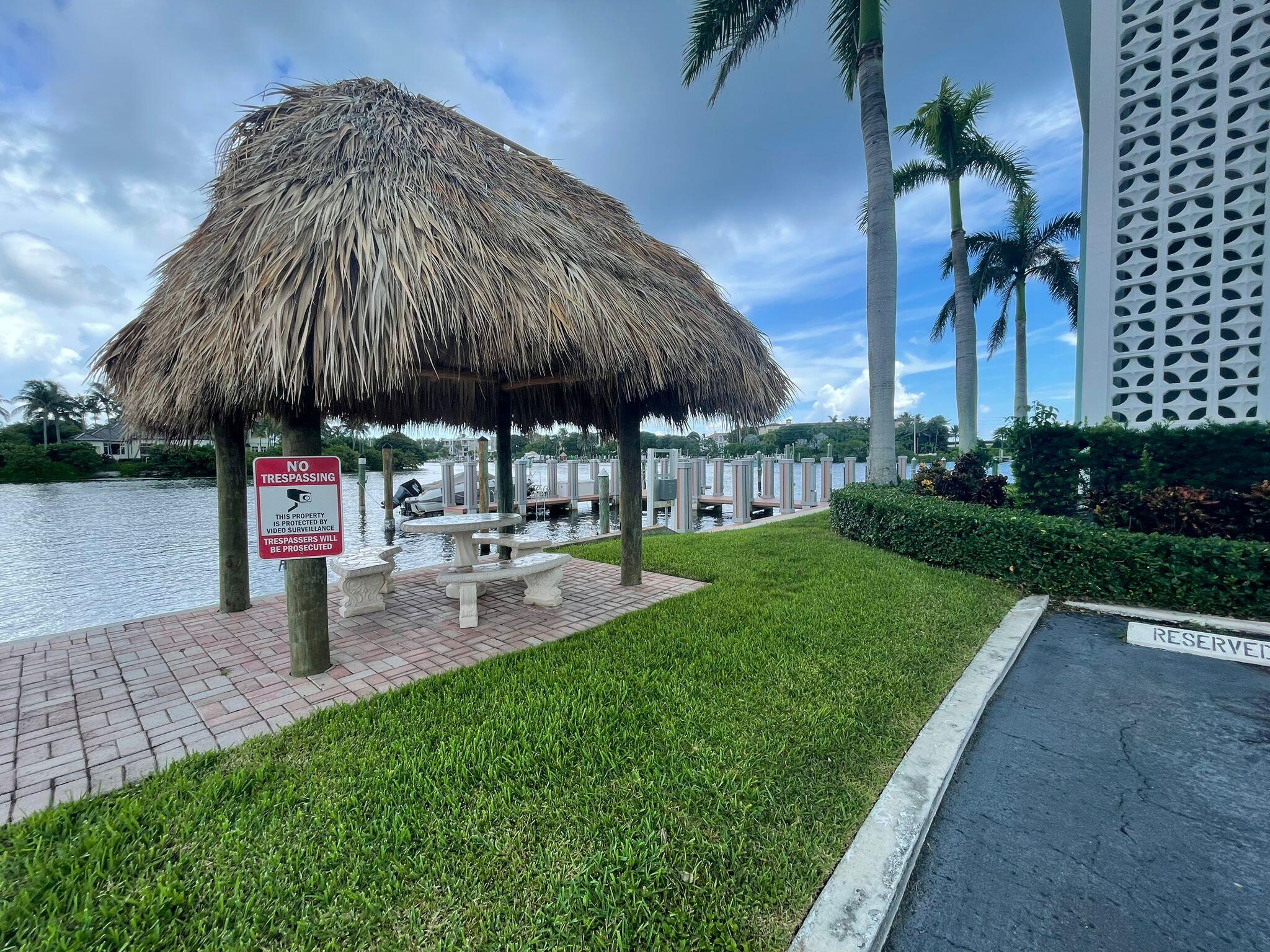 2772 Northeast 30th Avenue, Unit 6C Lighthouse Point, FL 33064 - Photo 6 of 16 a couple of table and chairs under an umbrella in backyard