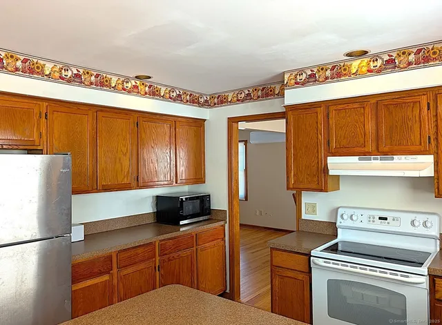 a kitchen with stainless steel appliances a refrigerator and a stove top oven