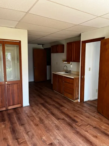 a kitchen with granite countertop a sink cabinets and wooden floor