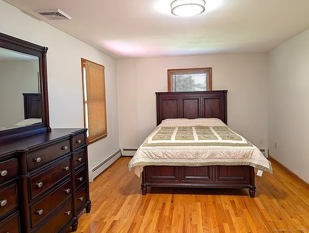 a bedroom with a bed and wooden floor