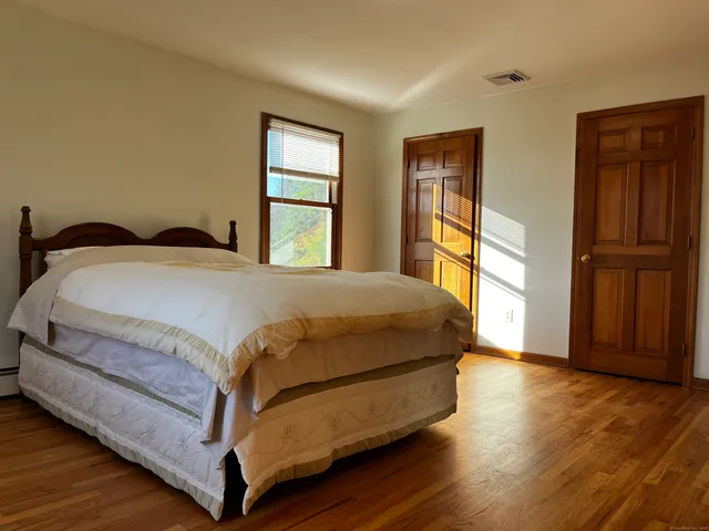 a bed sitting in a bedroom next to a window