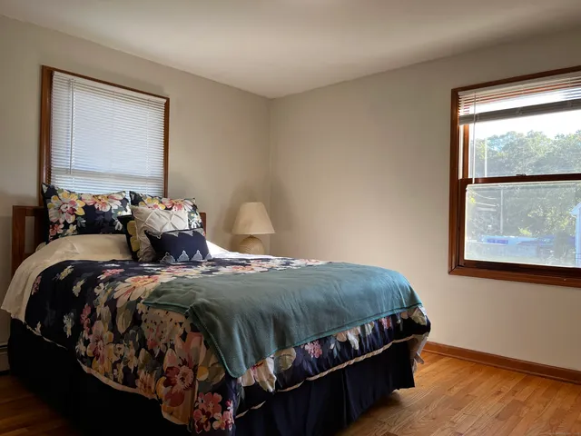 a bedroom with a bed and wooden floor