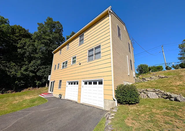 a view of a house with a yard and a garage