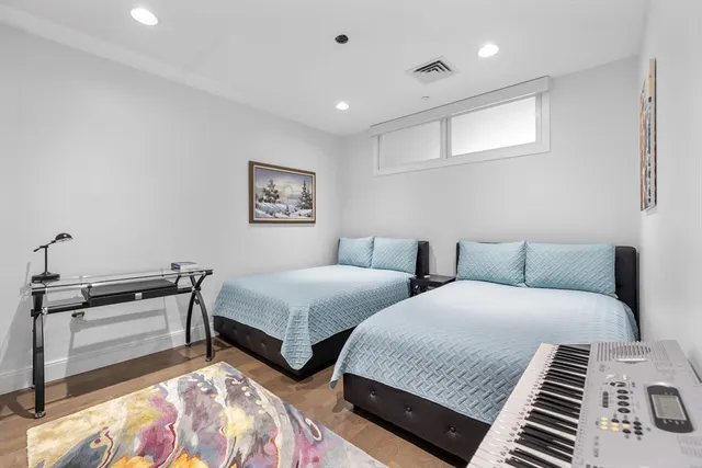 a spacious bedroom with two beds and a lamp