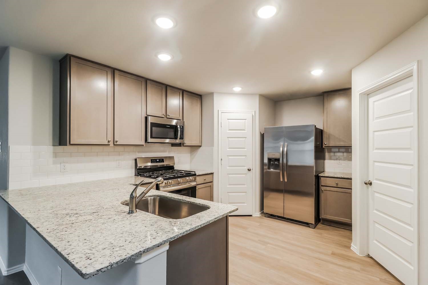24812 Scilla Way Montgomery, TX 77316 - Photo 8 of 18 a kitchen with stainless steel appliances granite countertop a sink stove and refrigerator