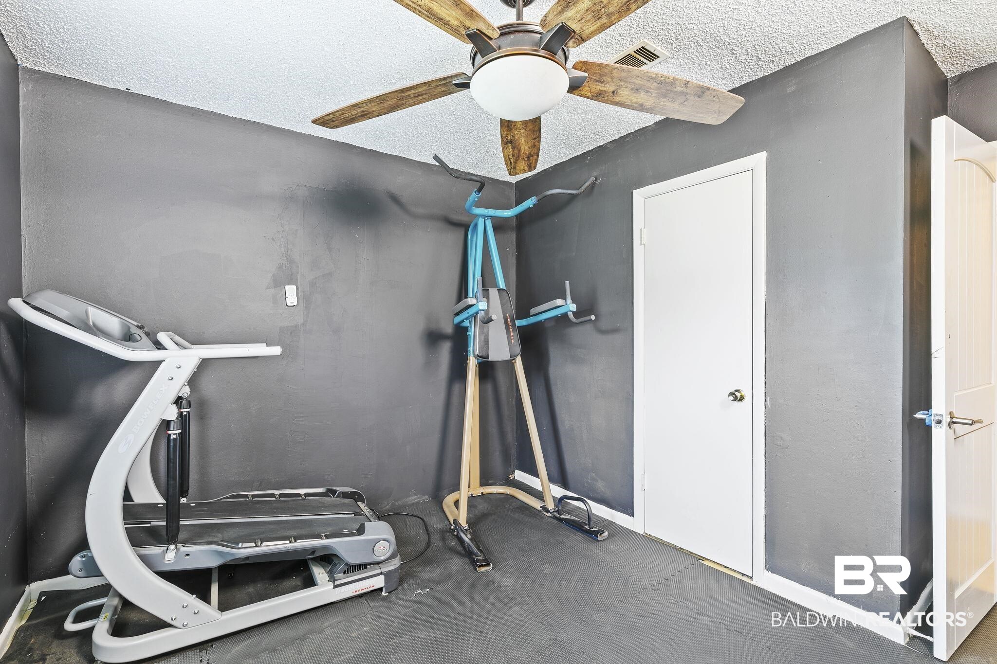 13108 6th Street Lillian, AL 36549 - Photo 29 of 39 Workout room with ceiling fan and a textured ceiling