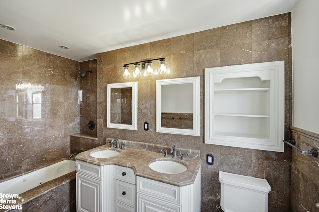 710 Park Avenue, Unit PH20B Manhattan, NY 10021 - Photo 12 of 20 a bathroom with a granite countertop sink toilet and mirror