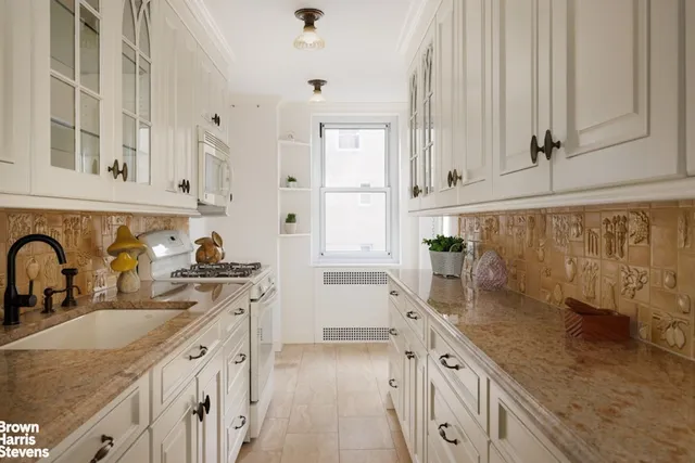 a kitchen with granite countertop a sink stove and cabinets