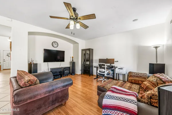 a living room with furniture a flat screen tv and a lamp