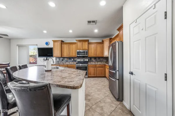 a kitchen with stainless steel appliances granite countertop a sink refrigerator and cabinets