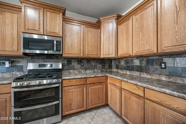 a kitchen with granite countertop a stove a microwave and cabinets