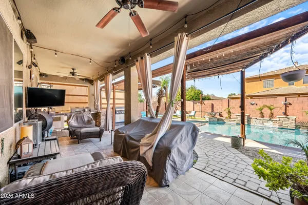 a living room with furniture a flat screen tv and a floor to ceiling window