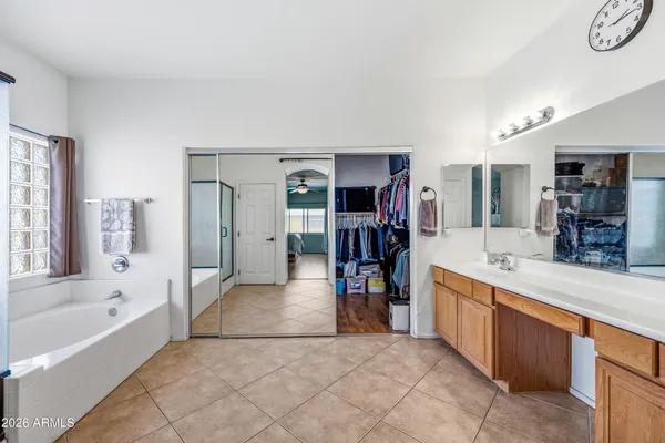 a spacious bathroom with a granite countertop sink a mirror and a shower