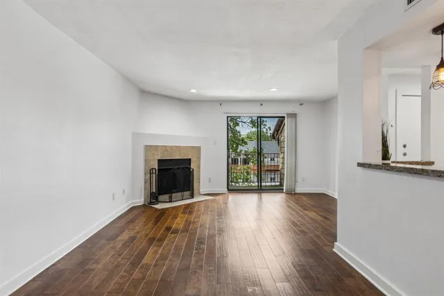 wooden floor fireplace and windows in an empty room
