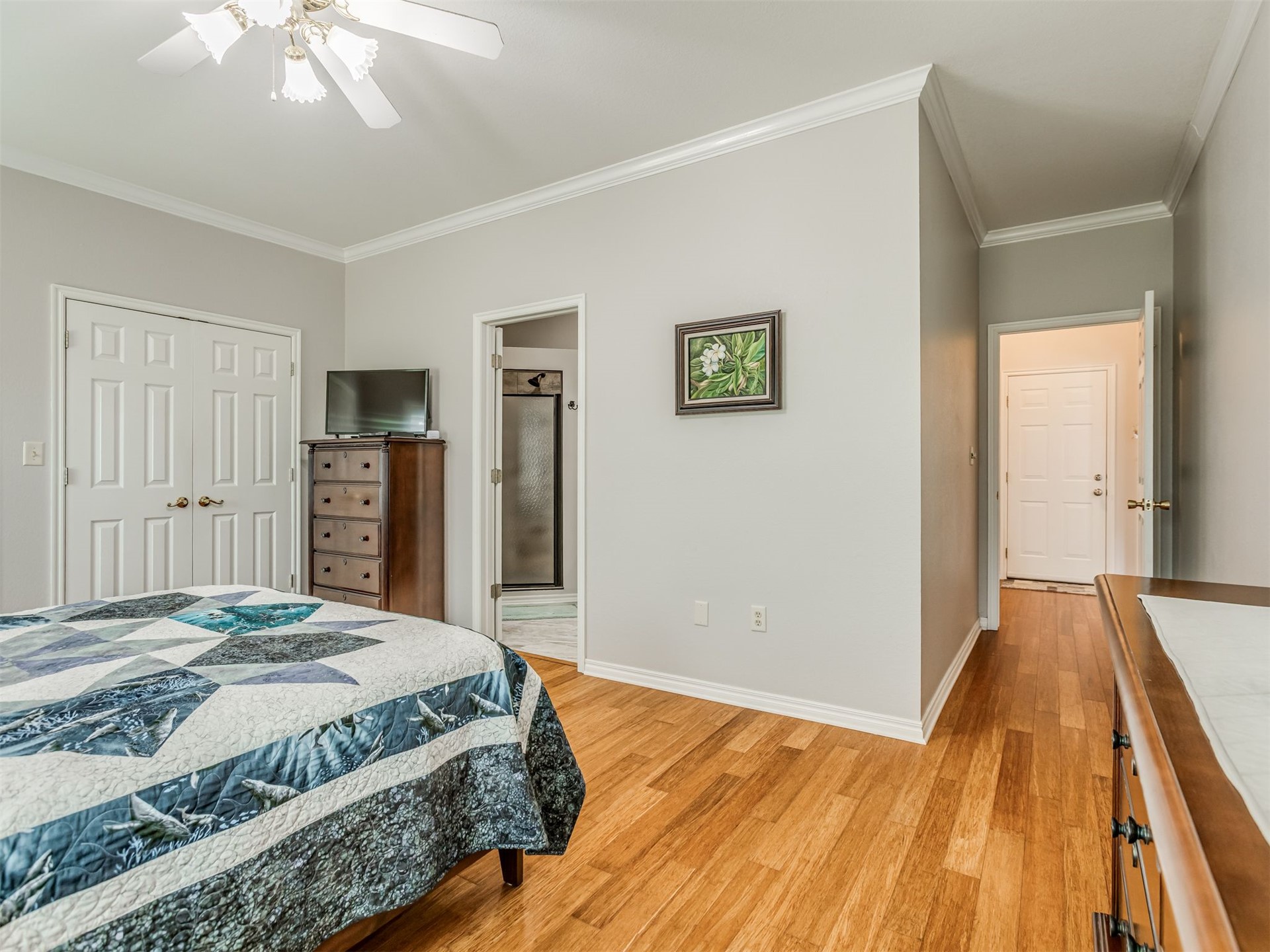119 Mainsail Road Stigler, OK 74462 - Photo 23 of 52 Hardwood flooring, crown molding, white trim, paneled doors, and a ceiling fan with integrated lighting