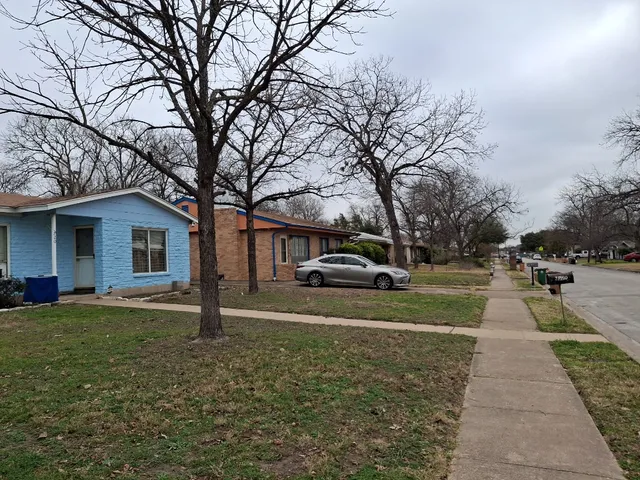 a front view of a house with a yard and trees