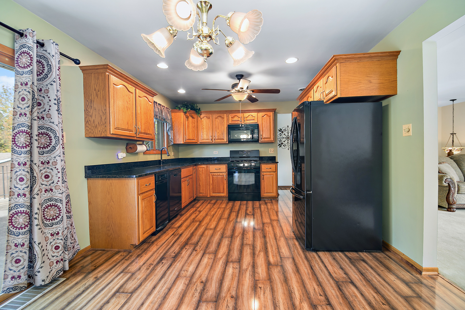 15124 Chestnut Lane Oak Forest, IL 60452 - Photo 5 of 18 a kitchen with stainless steel appliances granite countertop a refrigerator a sink dishwasher a dining table and chairs with wooden floor