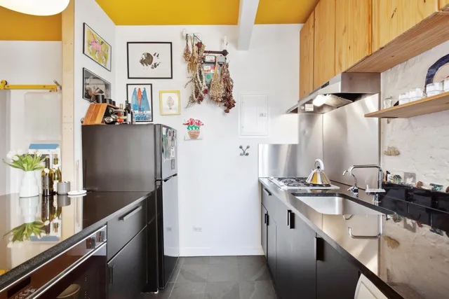a kitchen with stainless steel appliances granite countertop a sink a stove and a wooden floors